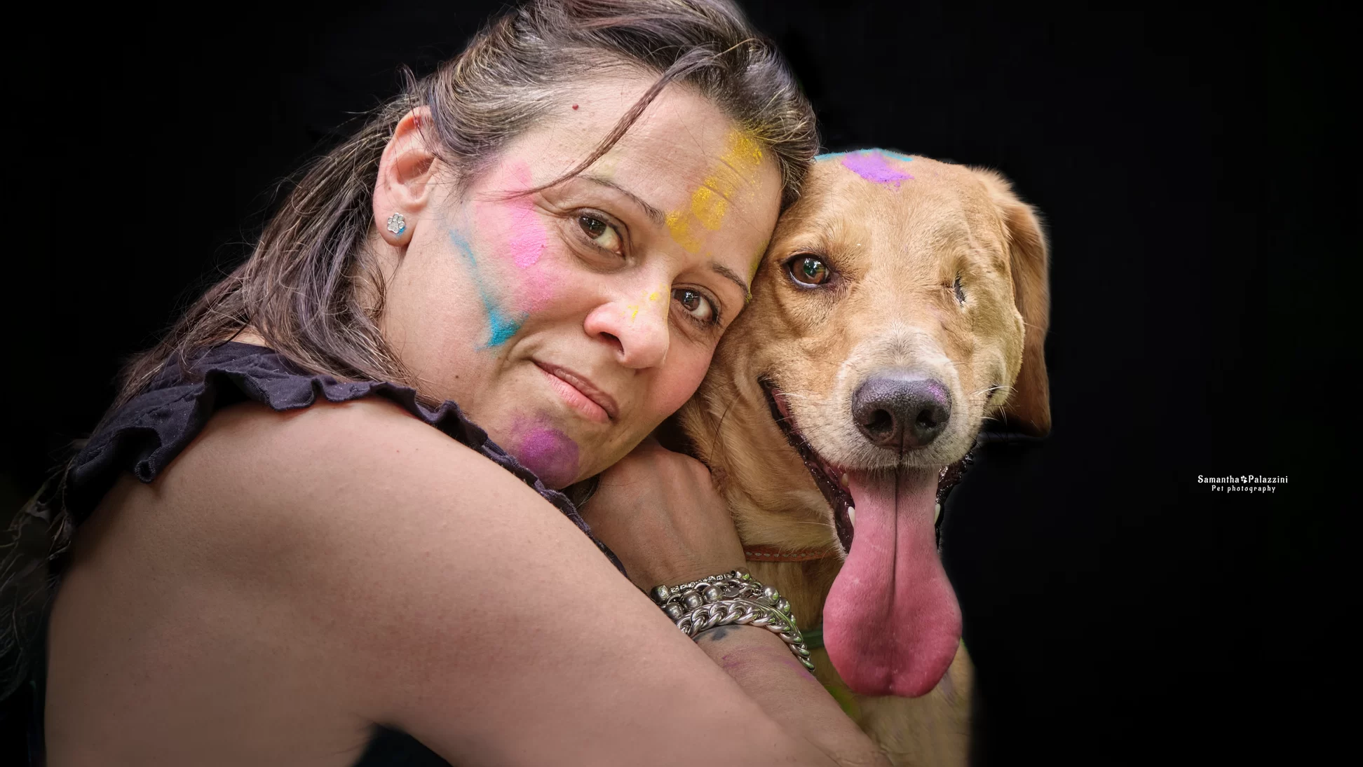 Foto di un cane senza un occhio, colorato da polveri holi, durante un servizio fotografico per cani